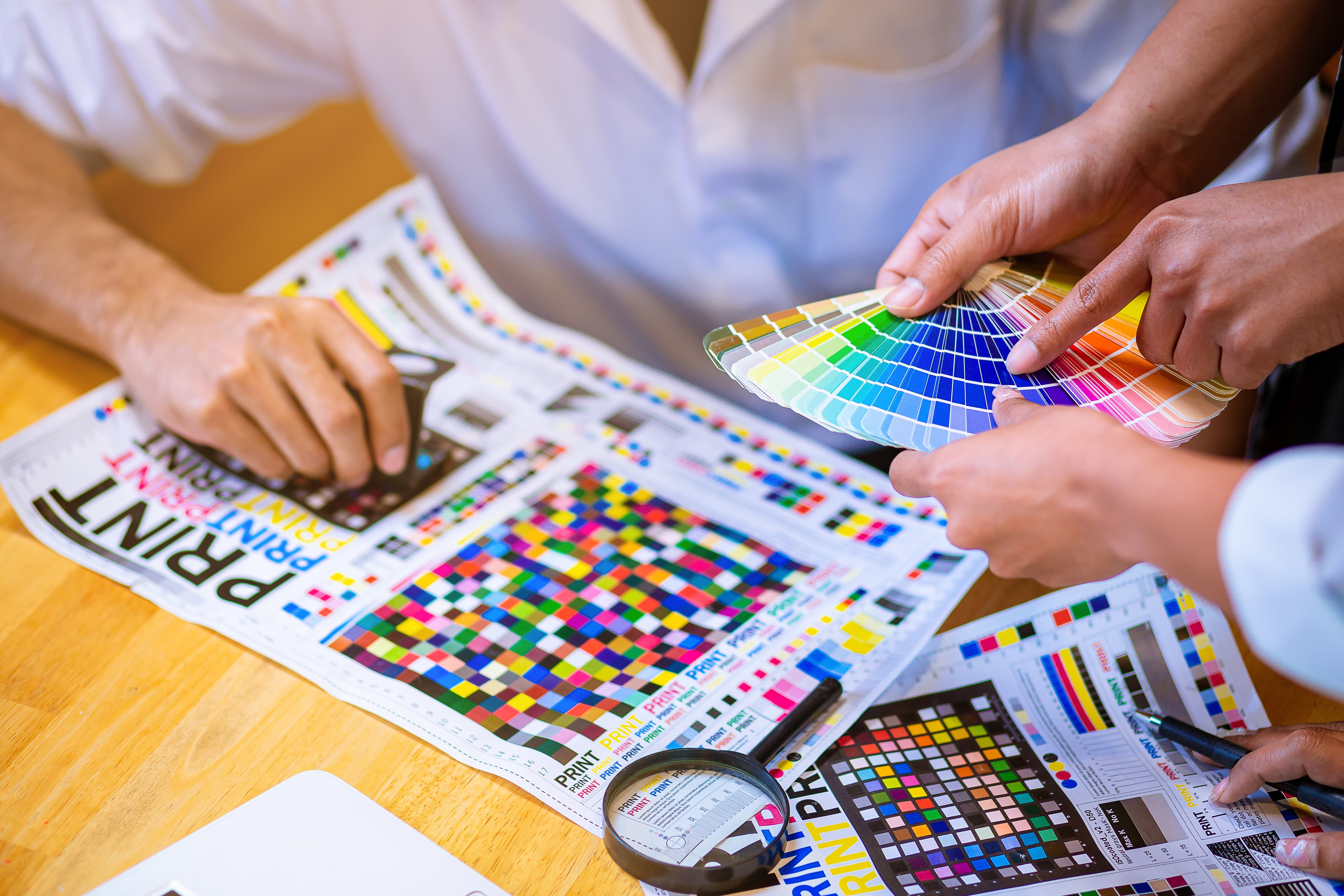 Team checking print quality against color guides and proof sheets